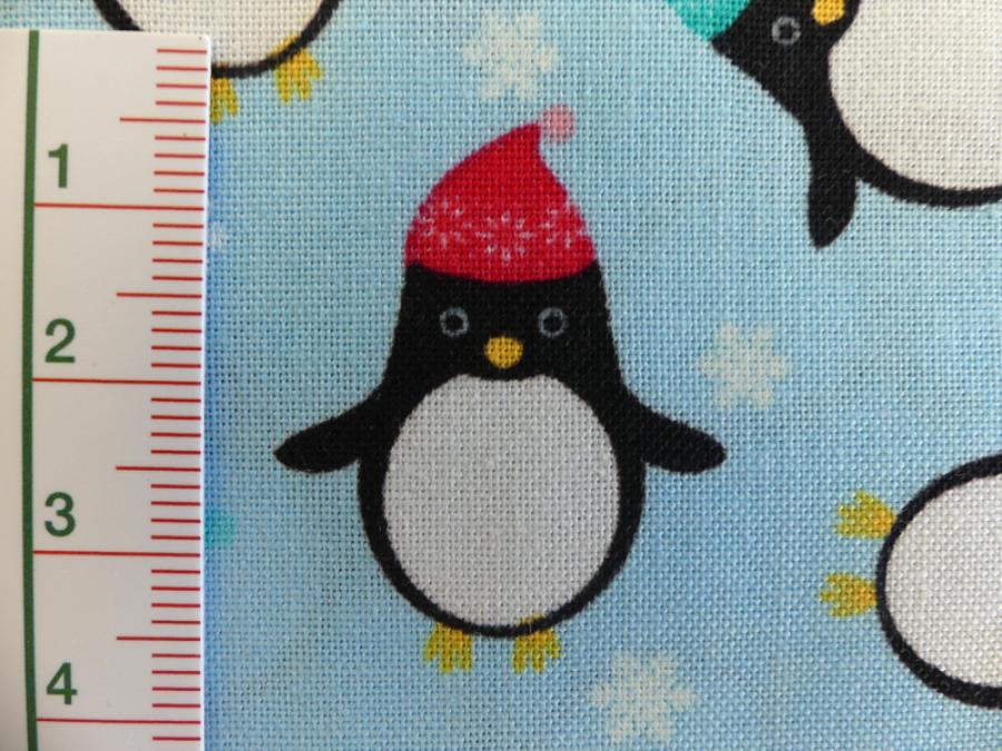 Preview: Patchworkstoff Pinguine mit Mütze auf helltürkis. Von Timeless Treasures. Detailansicht.